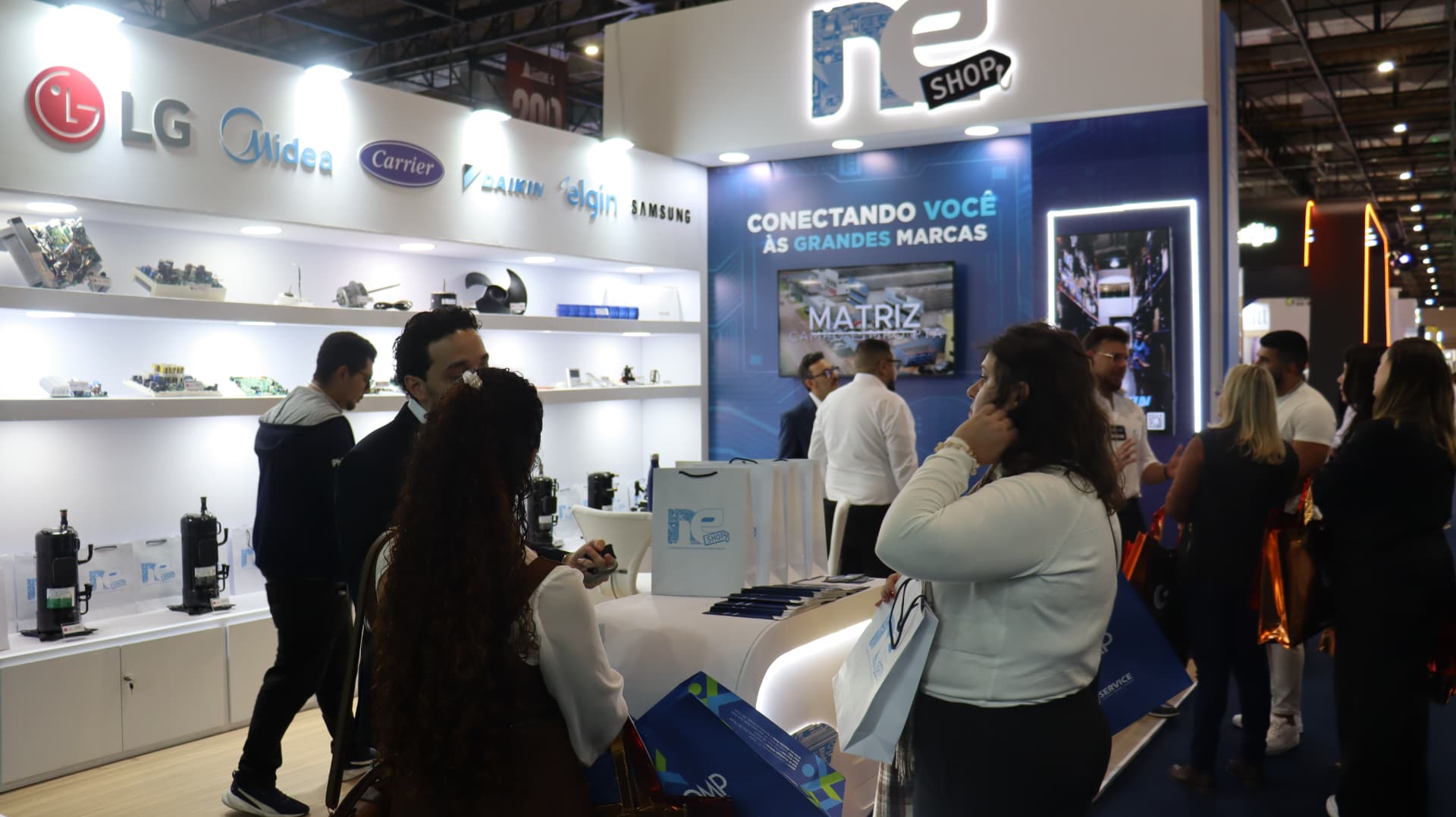 Visitantes conferindo peças no estande NESHOP